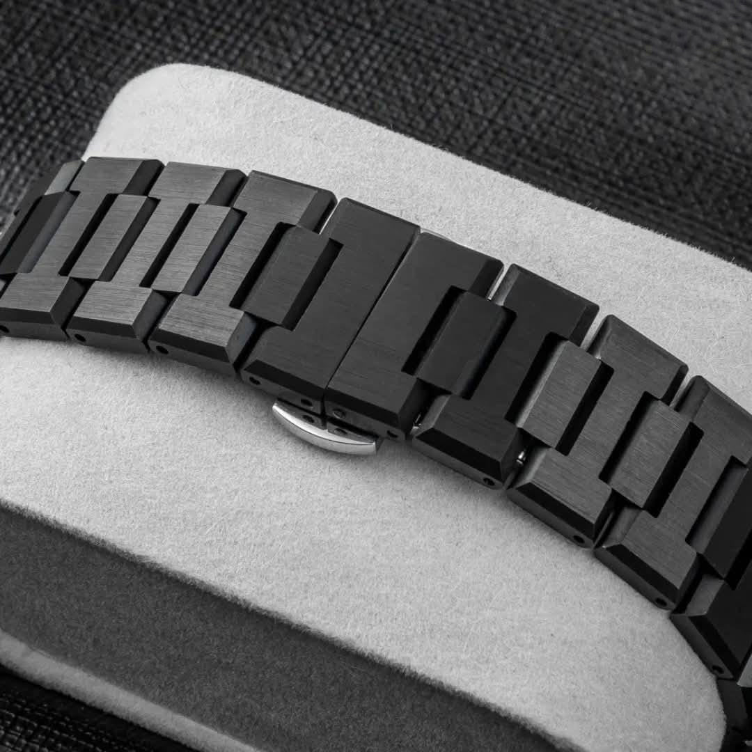 Black metal watch strap on a gray surface