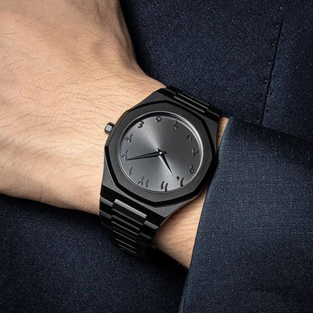 Black wristwatch on a person's wrist with a dark background